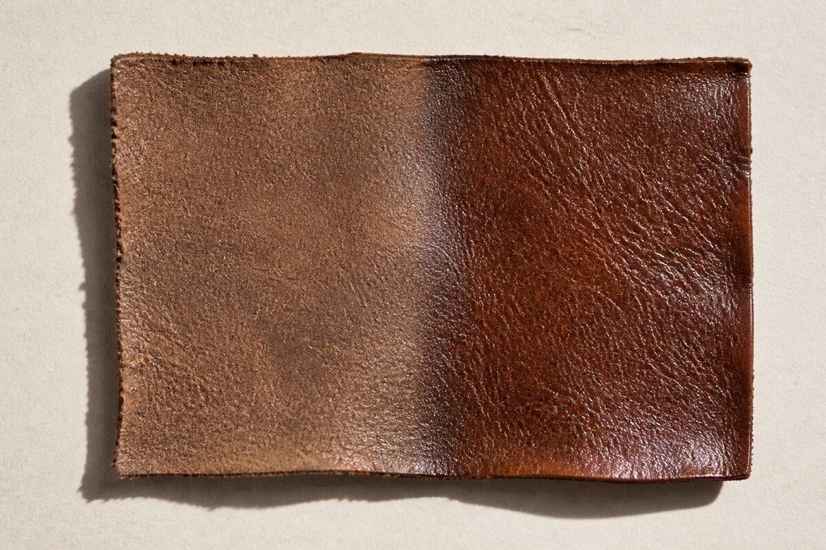 Brown leather sample showing a dry-feeling intact area beside a visibly cracked surface coating